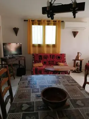 a living room with a table and a couch at Maison près de la plage in Penta-di-Casinca