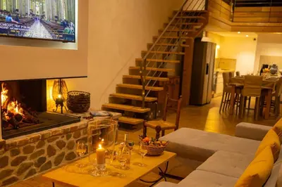 a living room with a fireplace and a staircase at Demeure de charme Suarella Domaine de Marquiliani in Aghione