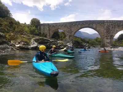 a group of people kayaking on a river with a bridge at Demeure de charme Suarella Domaine de Marquiliani in Aghione