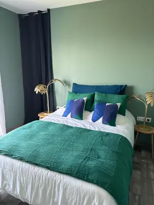 a green and white bed with blue pillows on it at Villa Casa di Simone Pietrosella Corse du Sud in Pietrosella