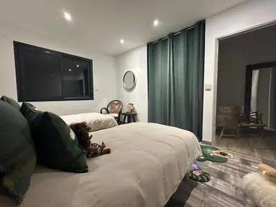 a small child sitting on a bed in a bedroom at Villa Casa di Simone Pietrosella Corse du Sud in Pietrosella