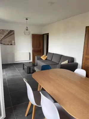 a living room with a table and a couch at Bas de villa pour 6 in Venzolasca