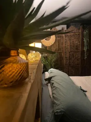 a bedroom with a bed and a table with a pillow at Maison familiale charmante in Borgo