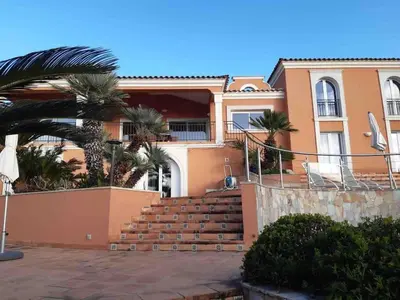 a house with stairs and palm trees in front of it at VILLA VUE MER in Pietrosella
