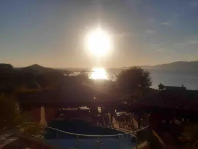 a view of the sun setting over the water at VILLA VUE MER in Pietrosella