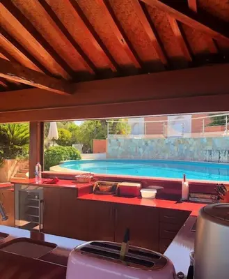 a kitchen with a swimming pool in the background at VILLA VUE MER in Pietrosella
