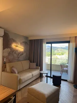 a living room with a couch and a large window at Résidence Apa Nera in Calenzana
