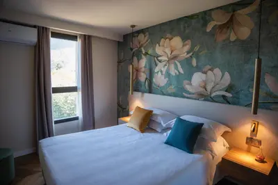 a bedroom with a large bed with a painting on the wall at Résidence Apa Nera in Calenzana
