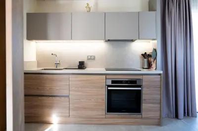a kitchen with white cabinets and a sink and a stove at Résidence Apa Nera in Calenzana