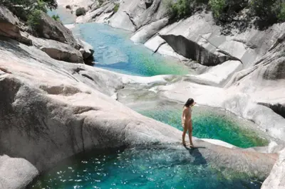 a woman standing in a pool of water in a river at Appartement T4 climatisé, lumineux et vue mer à Solenzara in Sari Solenzara