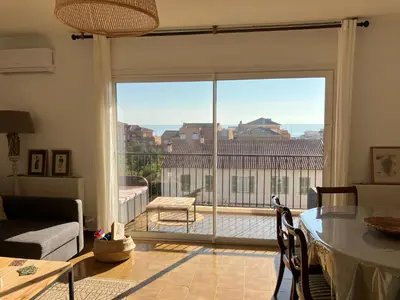 a living room with a large sliding glass door at Appartement T4 climatisé, lumineux et vue mer à Solenzara in Sari Solenzara