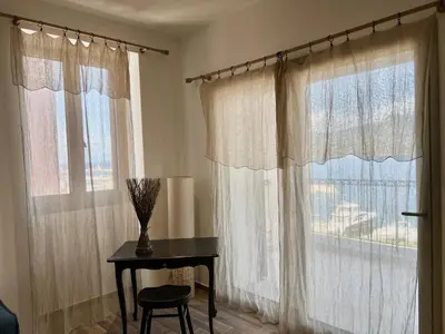 a room with curtains and a table and a window at Résidence Cas’Antica in Propriano