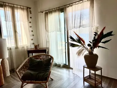 a living room with a chair and a potted plant at Résidence Cas’Antica in Propriano