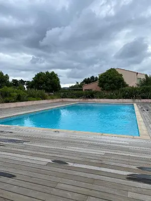 a large blue swimming pool on a wooden deck at Porto vecchio Résidence Don Andria T2 in Lecci