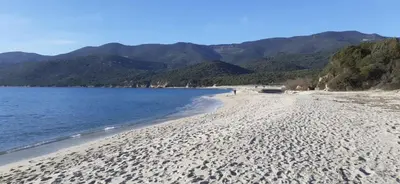 a view of a beach with mountains in the background at La bergerie de Cupabia in Serra-di-Ferro