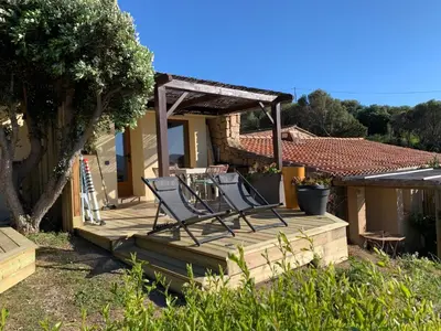 a couple of chairs sitting on a wooden deck at La bergerie de Cupabia in Serra-di-Ferro
