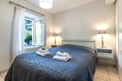 a bedroom with a blue bed with towels on it at Locations de La Casette d'Araggio in Porto-Vecchio
