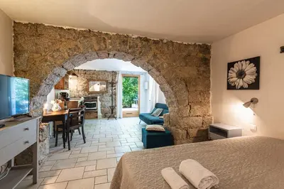 a bedroom with an archway and a living room at Locations de La Casette d'Araggio in Porto-Vecchio