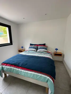 a bedroom with a bed with blue sheets and a window at Appartement T2 Casa Di Simone Pietrosella Corse du Sud in Pietrosella