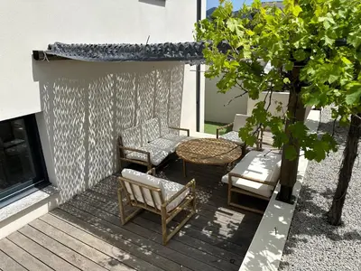 a patio with a table and chairs and a table and a tree at Appartement T2 Casa Di Simone Pietrosella Corse du Sud in Pietrosella