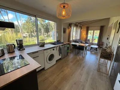 a kitchen with a washing machine and a living room at Gîte Cazoletta in Casalabriva