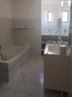 a white bathroom with a tub and a sink at Entre mer et montagne in Monte