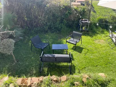 three chairs and a table in a yard at Rez de villa golfe de lava in Appietto