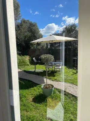 a view of a patio with an umbrella and a table at Rez de villa golfe de lava in Appietto