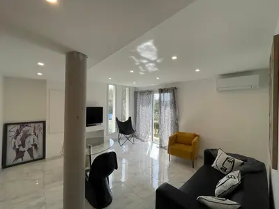 a living room with a couch and a table at Rez de villa golfe de lava in Appietto