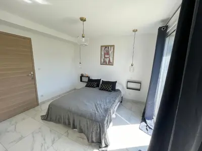a bedroom with a bed in a white room at Rez de villa golfe de lava in Appietto