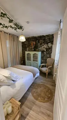 a bedroom with two beds and a stone wall at Maison de famille in Vallecalle