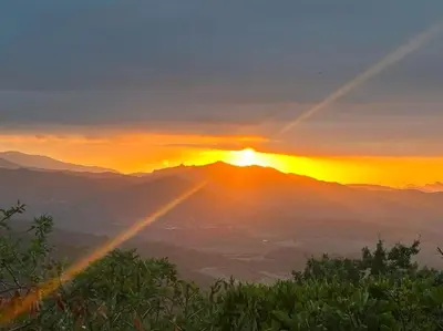 a sunset on top of a mountain with the sun setting at Maison de famille in Vallecalle
