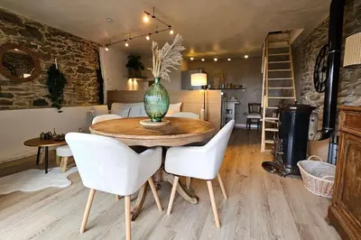 a dining room table with white chairs and a vase on it at Maison de famille in Vallecalle