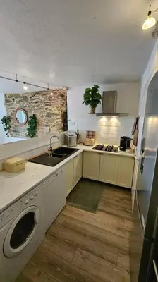 a kitchen with a sink and a washing machine at Maison de famille in Vallecalle