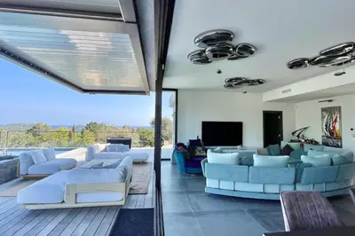 a living room with white furniture and a large window at Villa A Pinetta Villata in Sainte-Lucie de Porto-Vecchio
