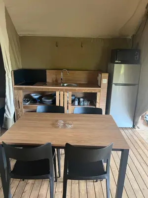 a kitchen with a table and chairs and a refrigerator at lodge lavallee in Belvédère