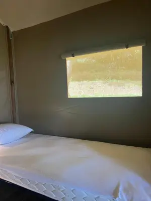 a small bedroom with a bed and a window at lodge lavallee in Belvédère