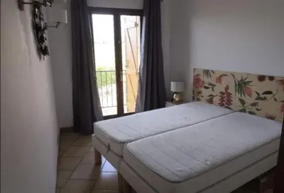a bedroom with a bed and a door with a window at Appartement vue mer Les hameaux de Propriano à Propriano in Propriano