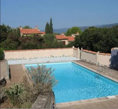 a large blue swimming pool in a yard at Appartement vue mer Les hameaux de Propriano à Propriano in Propriano