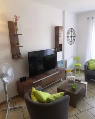 a living room with a large flat screen tv at Appartement vue mer Les hameaux de Propriano à Propriano in Propriano