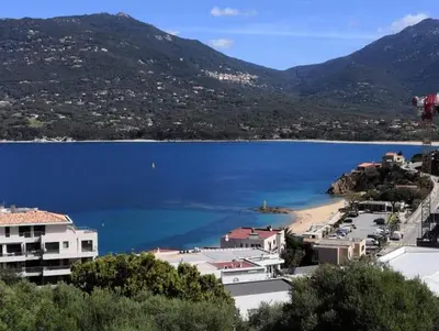 a view of a large body of water with mountains at Appartement vue mer Les hameaux de Propriano à Propriano in Propriano