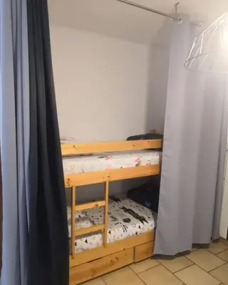 a room with two bunk beds and a curtain at Appartement vue mer Les hameaux de Propriano à Propriano in Propriano