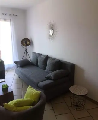 a living room with a couch and a table at Appartement vue mer Les hameaux de Propriano à Propriano in Propriano