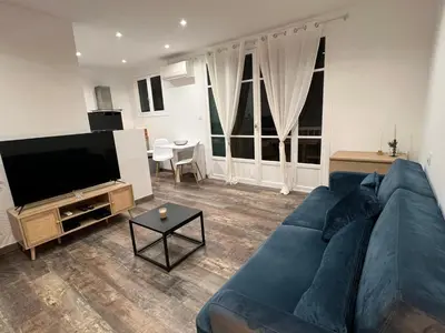 a living room with a blue couch and a flat screen tv at Appartement Centre Ville Dea in Ajaccio