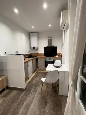 a kitchen with a white table and a white chair at Appartement Centre Ville Dea in Ajaccio