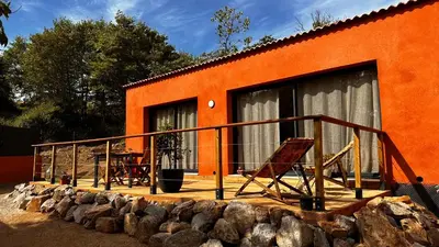 an orange house with a deck with a table and chairs at Maison 47m2 à 10min des plages - billard, baby, salle de sport, jardin in Ajaccio