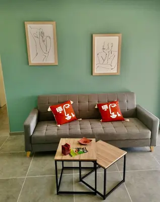 a living room with a couch with red pillows and a table at La villa Résia in Peri