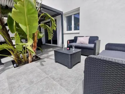 a patio with two chairs and a table and plants at La villa Résia in Peri