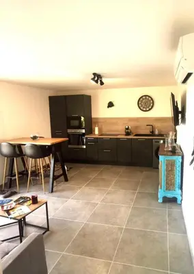 a living room with a kitchen and a table at La villa Résia in Peri