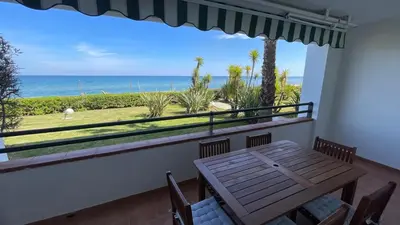 a dining room with a table and a view of the ocean at Appartement T3 les pieds dans l'eau in Moriani Plage